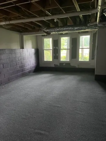 a view of an empty room with a fireplace and a window