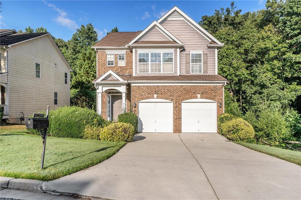 a front view of a house with a yard and garage