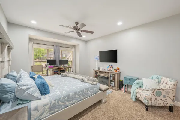 a bedroom with furniture and a flat screen tv