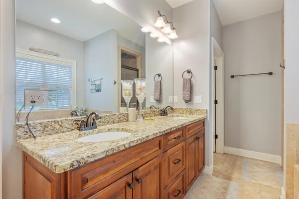 a bathroom with a granite countertop double vanity sink and a mirror