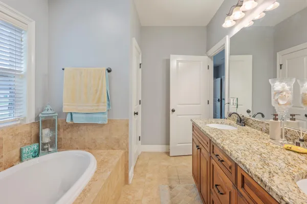 a spacious bathroom with a granite countertop tub sink and mirror