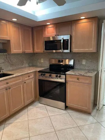 a kitchen with stainless steel appliances granite countertop a stove a sink and a microwave