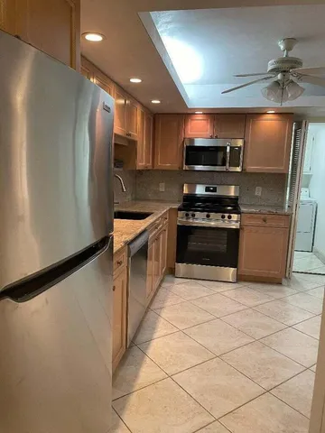 a kitchen with stainless steel appliances granite countertop a stove a refrigerator and a microwave
