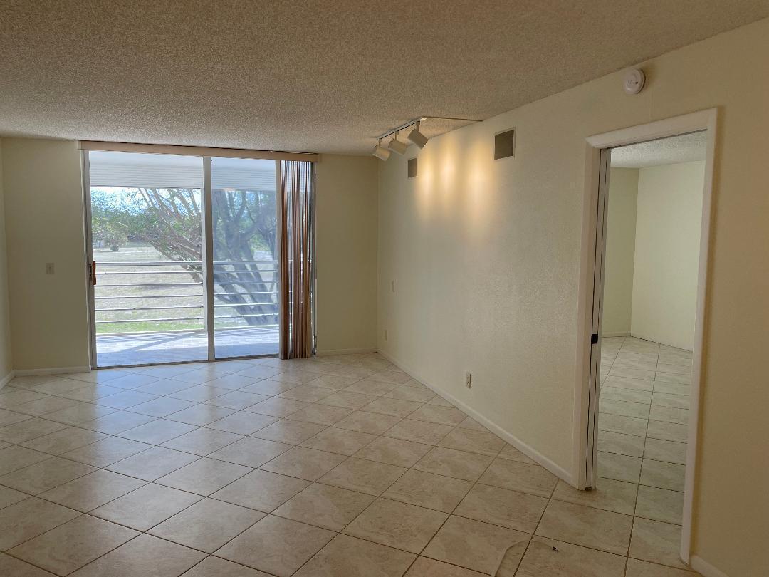 6300 Northwest 2nd Avenue, Unit 305 Boca Raton, FL 33487 - Photo 5 of 27 en empty room with sliding door and balcony view