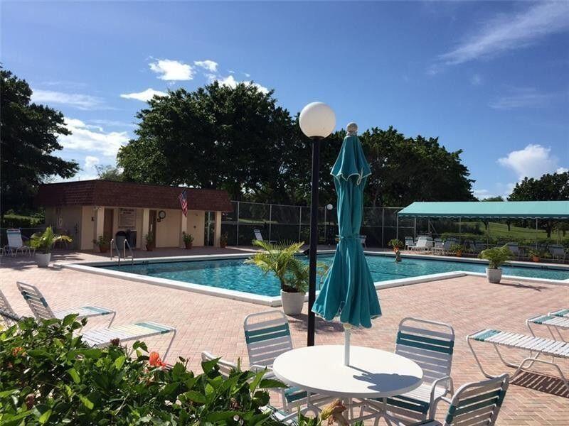 6300 Northwest 2nd Avenue, Unit 305 Boca Raton, FL 33487 - Photo 8 of 27 a view of a patio with table and chairs potted plants with wooden fence
