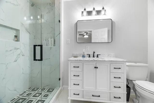 a bathroom with a double vanity sink a mirror a toilet and