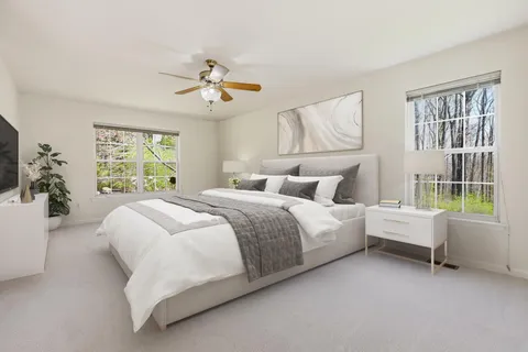 a spacious bedroom with a bed and a flat screen tv