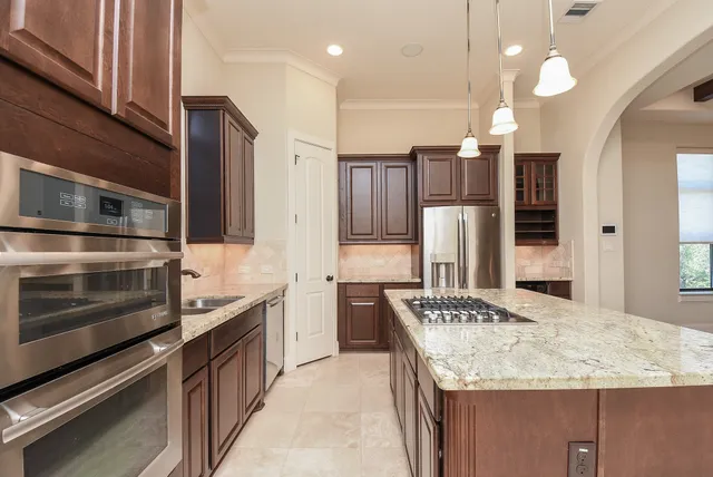 a kitchen with stainless steel appliances granite countertop a sink and a refrigerator