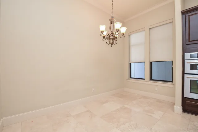 en empty room with windows and chandelier
