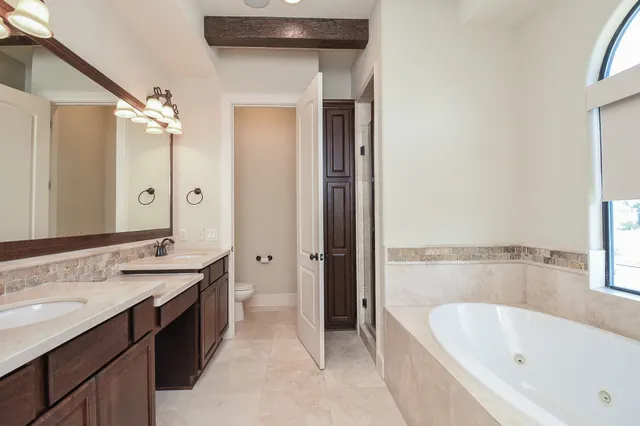 a bathroom with a tub sink and mirror