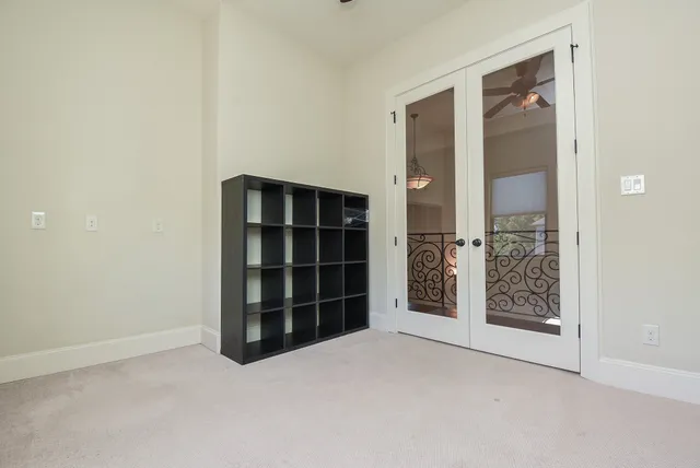 a view of an empty room with closet and wooden shelves