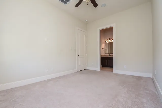 an empty room with closet and a ceiling fan