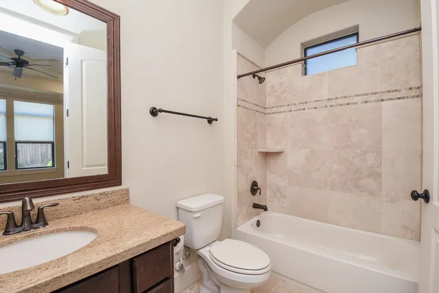 a bathroom with a granite countertop sink toilet and shower