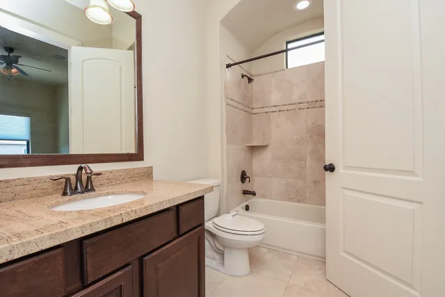 a bathroom with a granite countertop sink toilet and shower