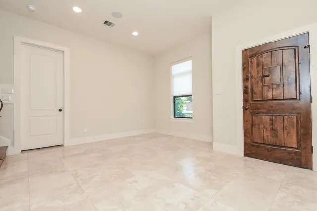 an empty room with windows and cabinet
