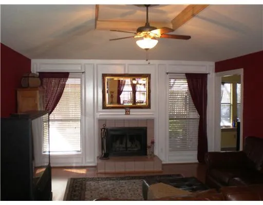 a view of a livingroom with a fireplace wooden floor and windows