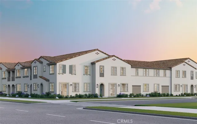 a front view of a white house with a big yard and potted plants