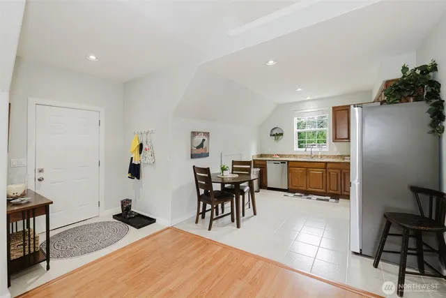 a kitchen with stainless steel appliances granite countertop a refrigerator a stove a sink dishwasher and white cabinets with wooden floor