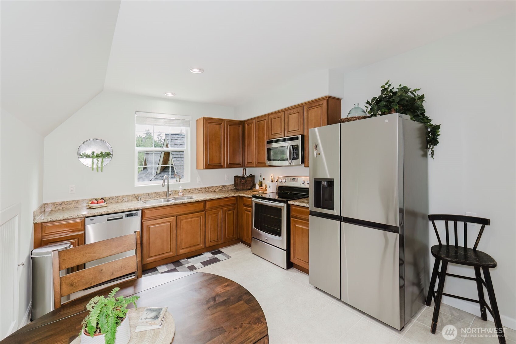 14113 84th Ave Court Northwest Gig Harbor, WA 98329 - Photo 33 of 40 a kitchen with stainless steel appliances granite countertop a refrigerator a stove a sink dishwasher and white cabinets with wooden floor