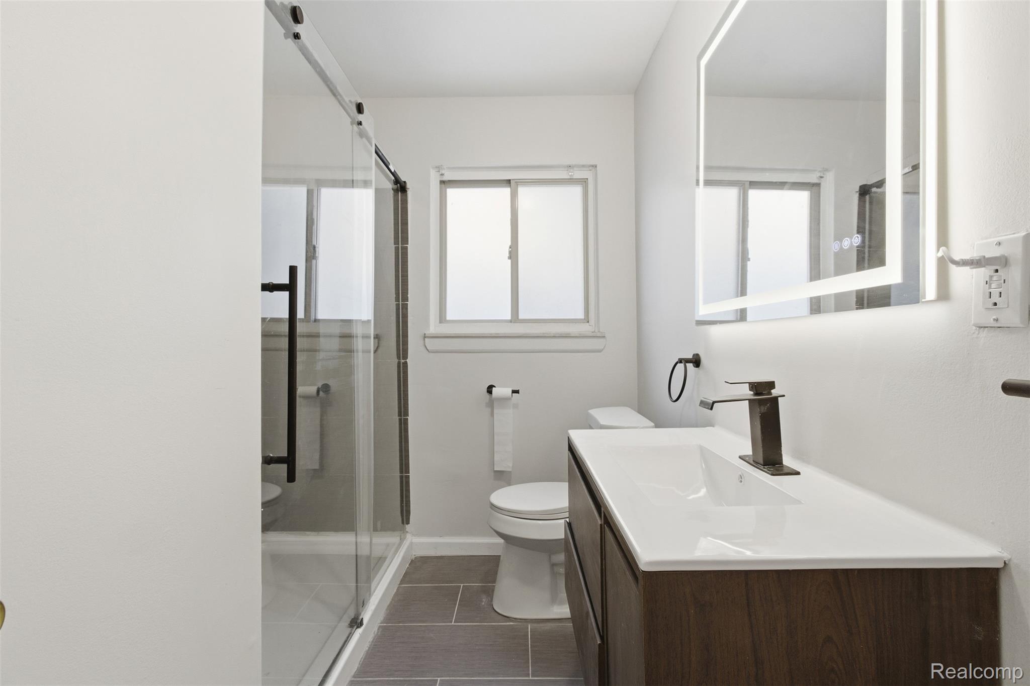 14731 Stephens Road Eastpointe, MI 48021 - Photo 13 of 15 Full bath with vanity, a shower stall, and dark tile patterned floors