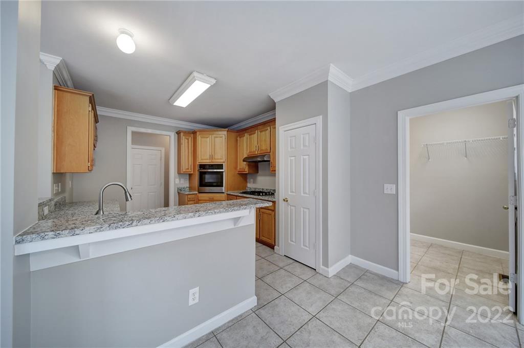 1711 Copperplate Road Charlotte, NC 28262 - Photo 17 of 48 a kitchen with kitchen island granite countertop a sink cabinets and stainless steel appliances