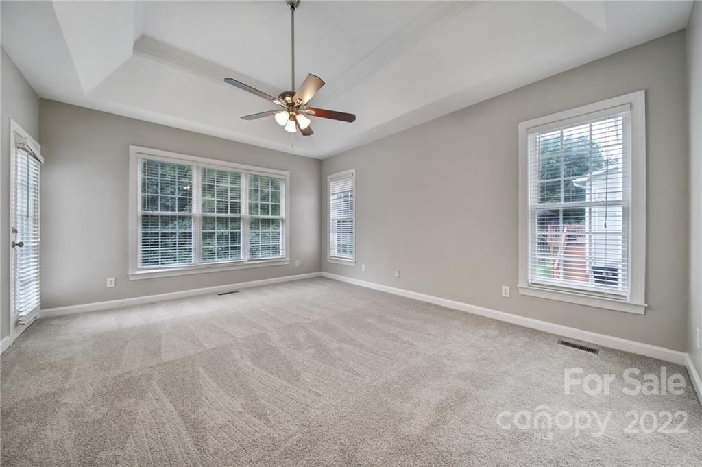 1711 Copperplate Road Charlotte, NC 28262 - Photo 19 of 48 an empty room with windows and ceiling fan