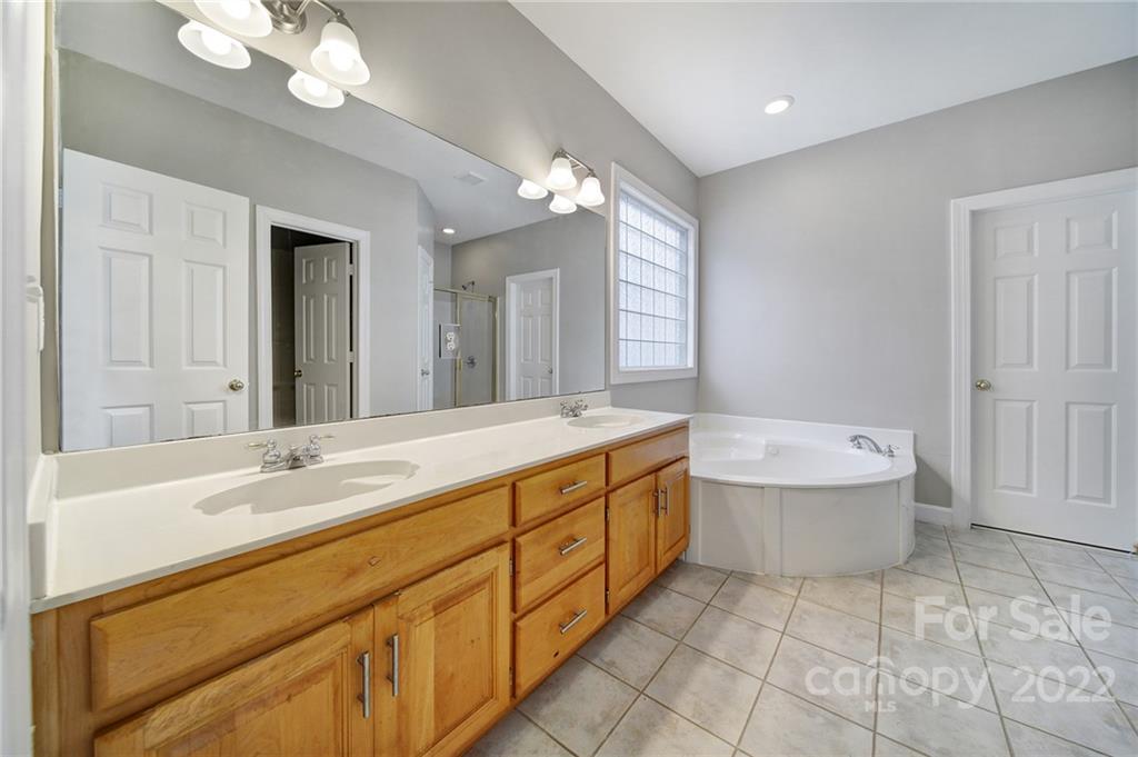 1711 Copperplate Road Charlotte, NC 28262 - Photo 22 of 48 a spacious bathroom with a granite countertop sink a toilet mirror and bathtub