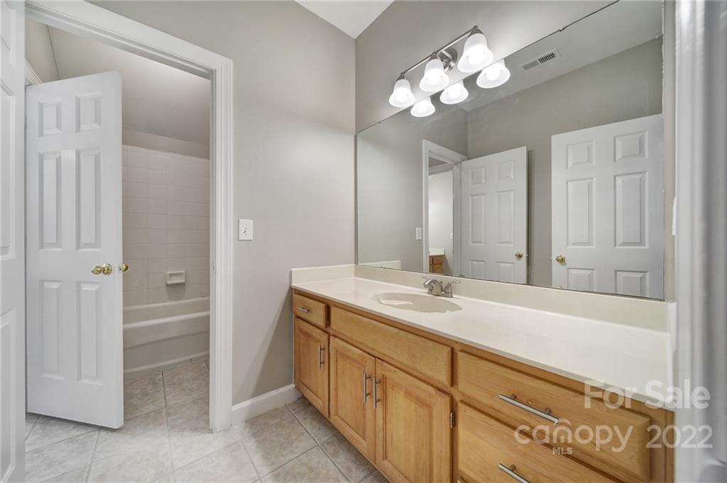 1711 Copperplate Road Charlotte, NC 28262 - Photo 31 of 48 a spacious bathroom with a granite countertop sink a light fixture and a mirror