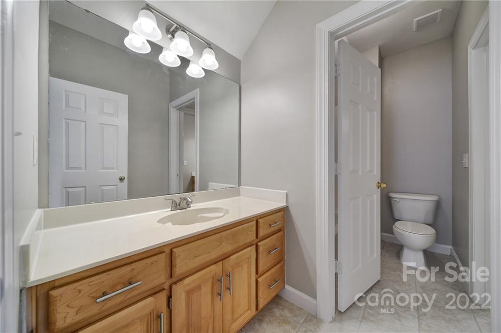 1711 Copperplate Road Charlotte, NC 28262 - Photo 36 of 48 a bathroom with a sink a toilet and a large mirror