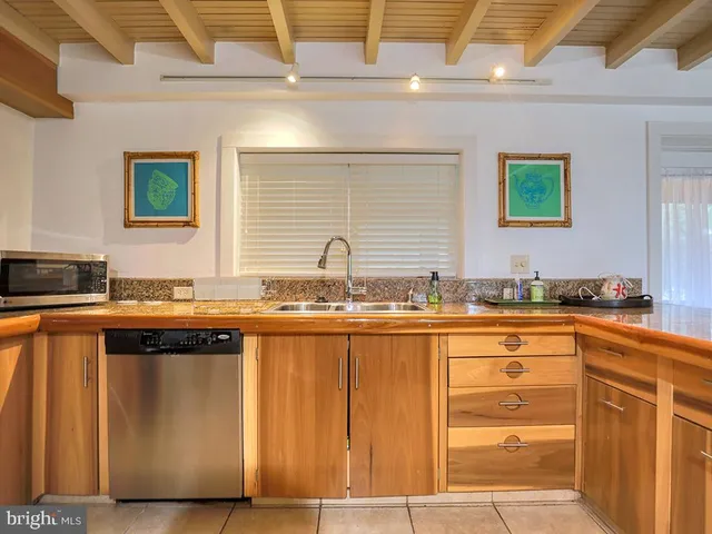 a kitchen with granite countertop a sink and a wooden cabinets