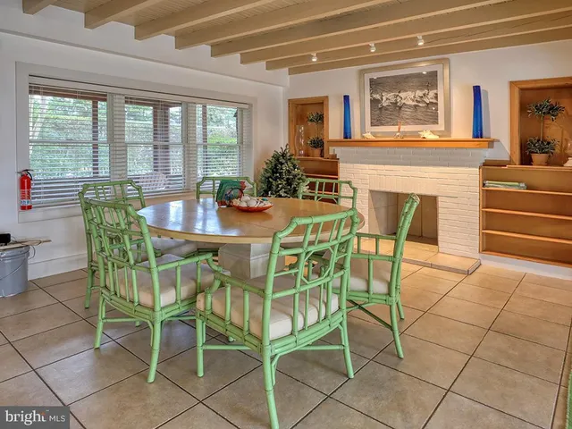 a dining room with furniture and large windows