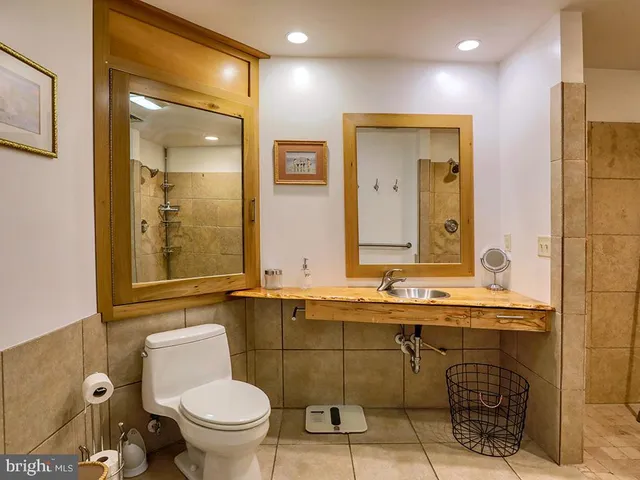 a spacious bathroom with a toilet a sink and mirror
