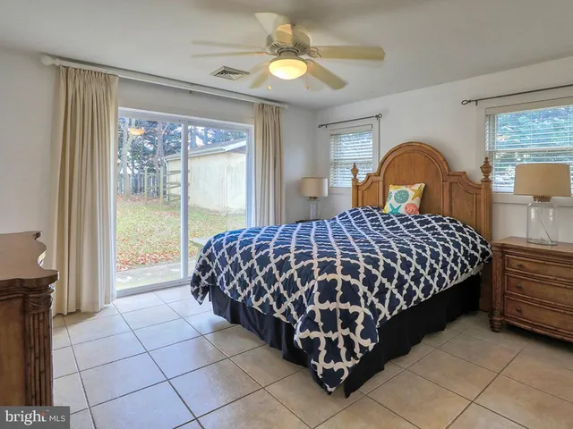 a view of a house with a yard and large trees