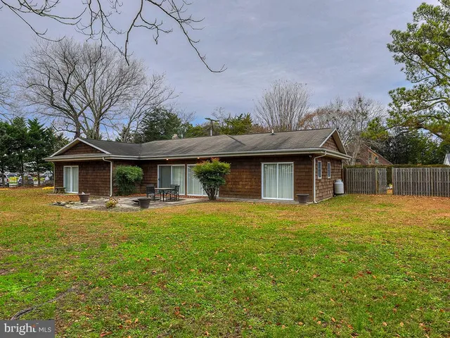 a view of a wooden dinning table and chairs in the garden