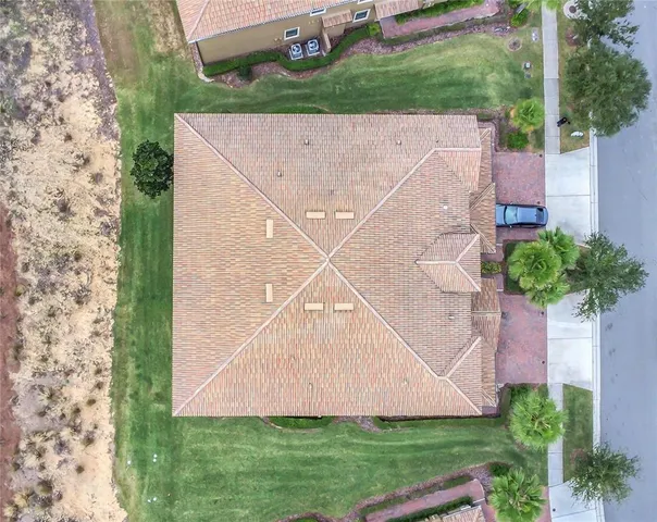 an aerial view of a house with a yard and a large tree