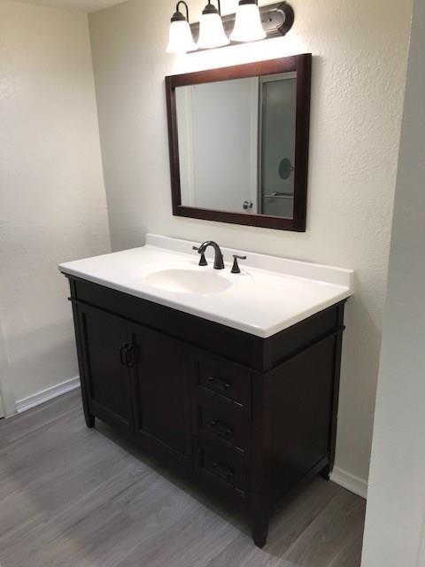 18240 Midway Road, Unit 303 Dallas, TX 75287 - Photo 17 of 22 Bathroom featuring vanity and light wood-style floors