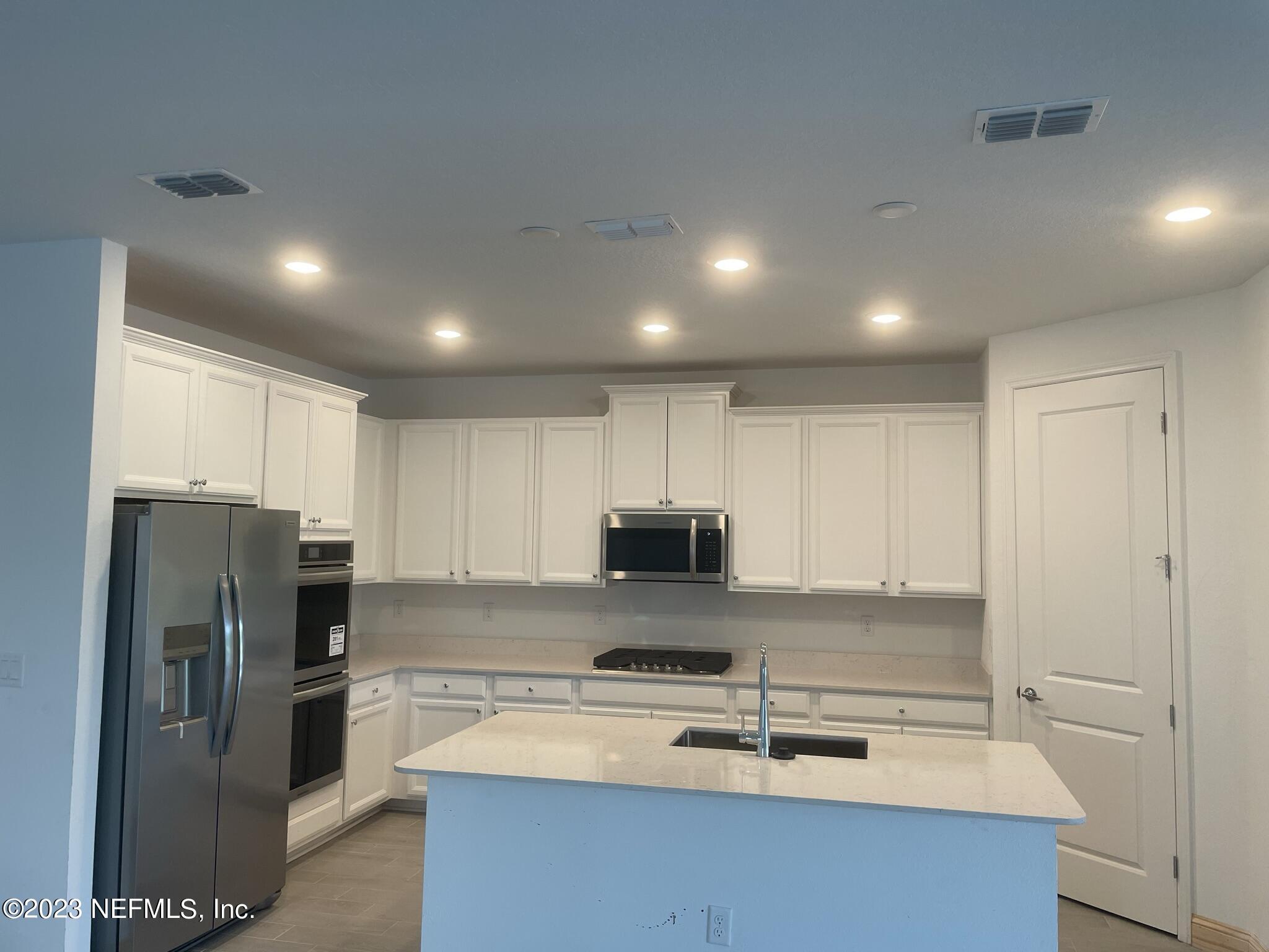 35 Hammer Circle St. Johns, FL 32259 - Photo 2 of 22 a kitchen with stainless steel appliances a refrigerator a stove a sink and white cabinets