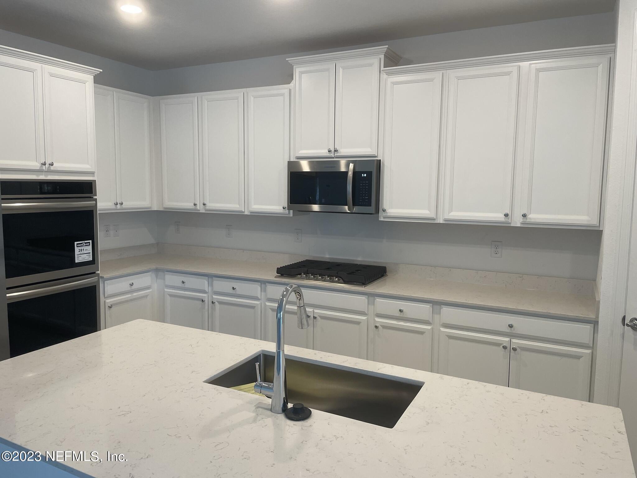 35 Hammer Circle St. Johns, FL 32259 - Photo 6 of 22 a kitchen with granite countertop a stove a sink and a microwave