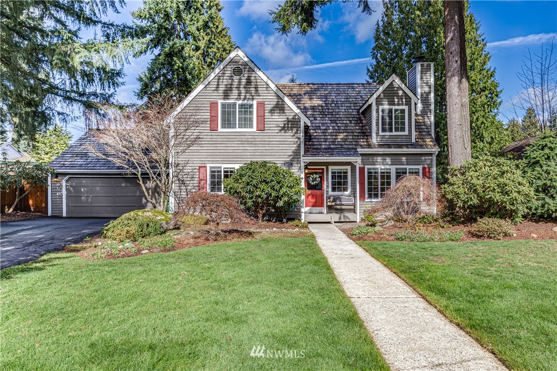 a front view of a house with a yard and green space