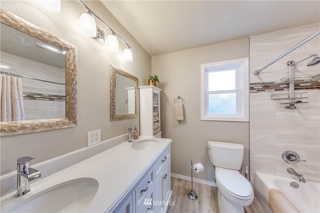 3121 166th Place Southeast Bothell, WA 98012 - Photo 22 of 28 a bathroom with a granite countertop toilet sink and mirror