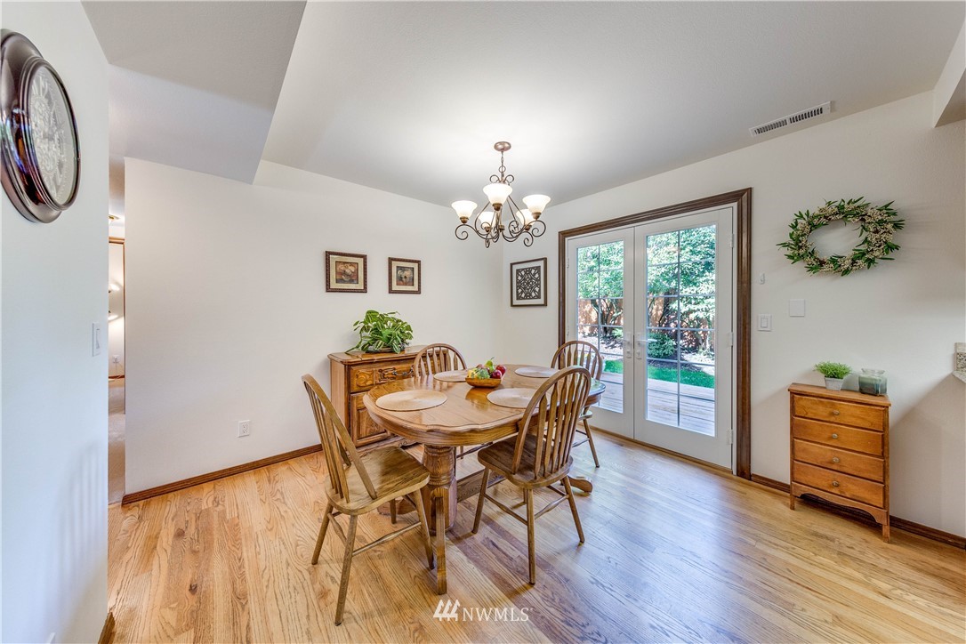3121 166th Place Southeast Bothell, WA 98012 - Photo 7 of 28 a dining room with furniture potted plants and wooden floor