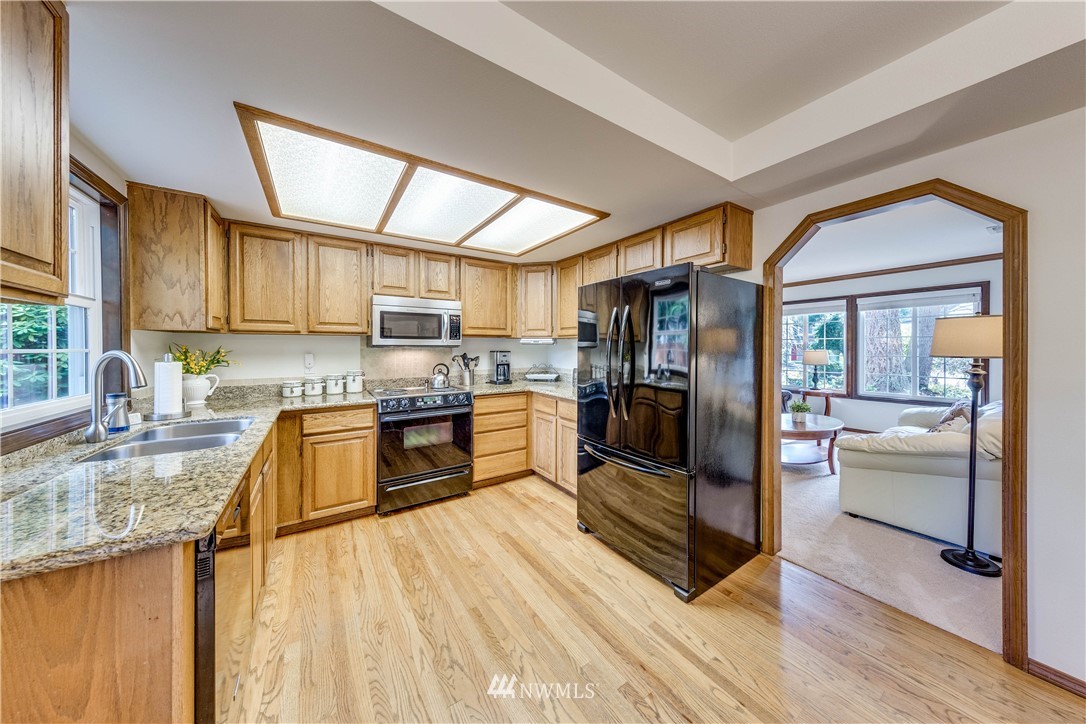 3121 166th Place Southeast Bothell, WA 98012 - Photo 8 of 28 a kitchen with stainless steel appliances granite countertop a refrigerator stove and sink