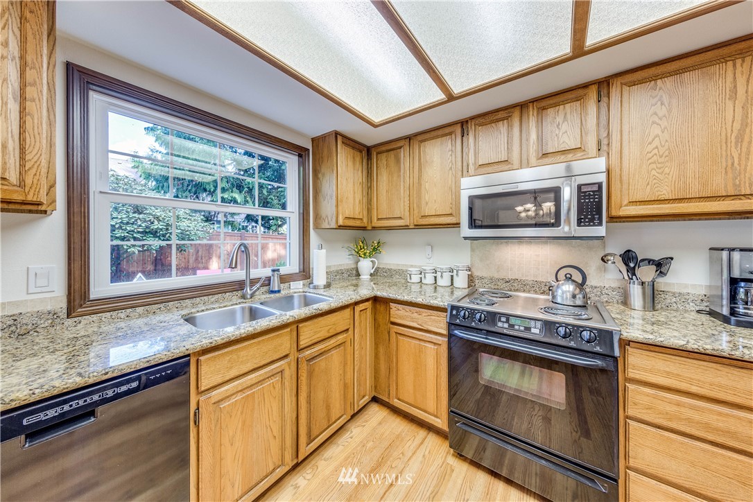 3121 166th Place Southeast Bothell, WA 98012 - Photo 9 of 28 a kitchen with stainless steel appliances granite countertop a sink a stove and cabinets