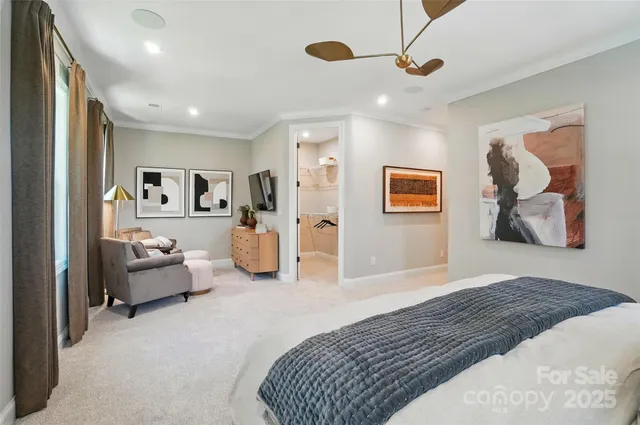 a spacious bedroom with a bed couch and view of living room
