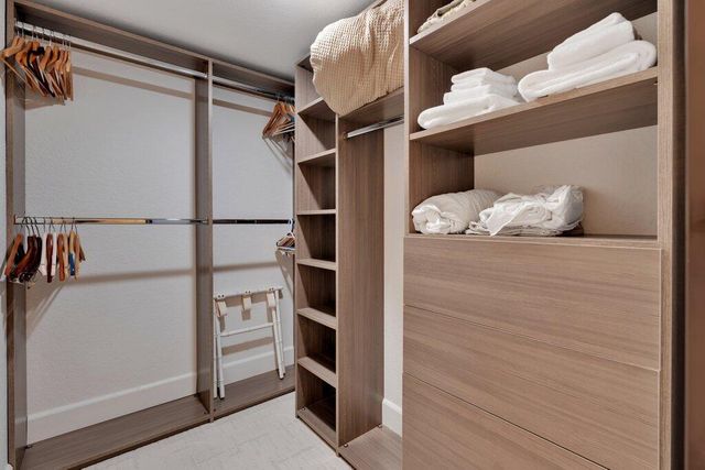 a view of walk in closet with empty racks