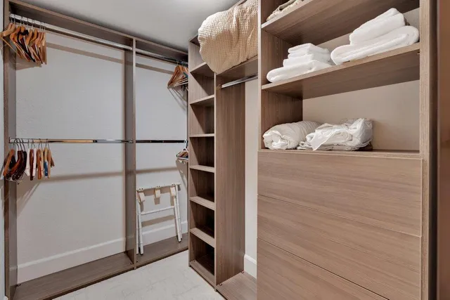 a view of walk in closet with empty racks