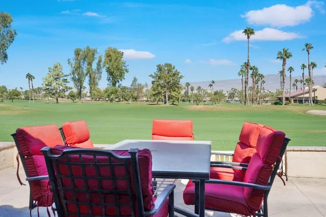 a patio with wooden floor table and chairs