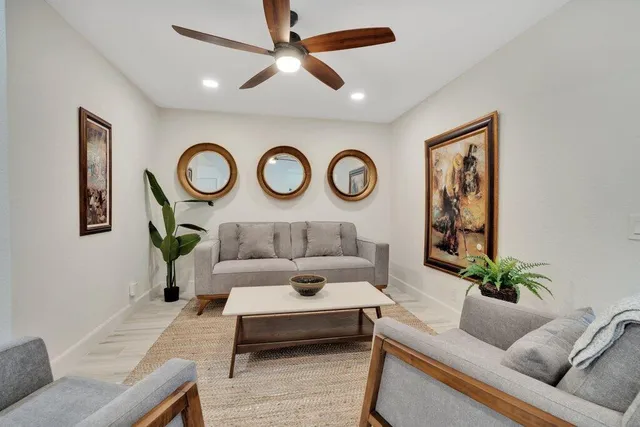 a living room with furniture a clock and a window