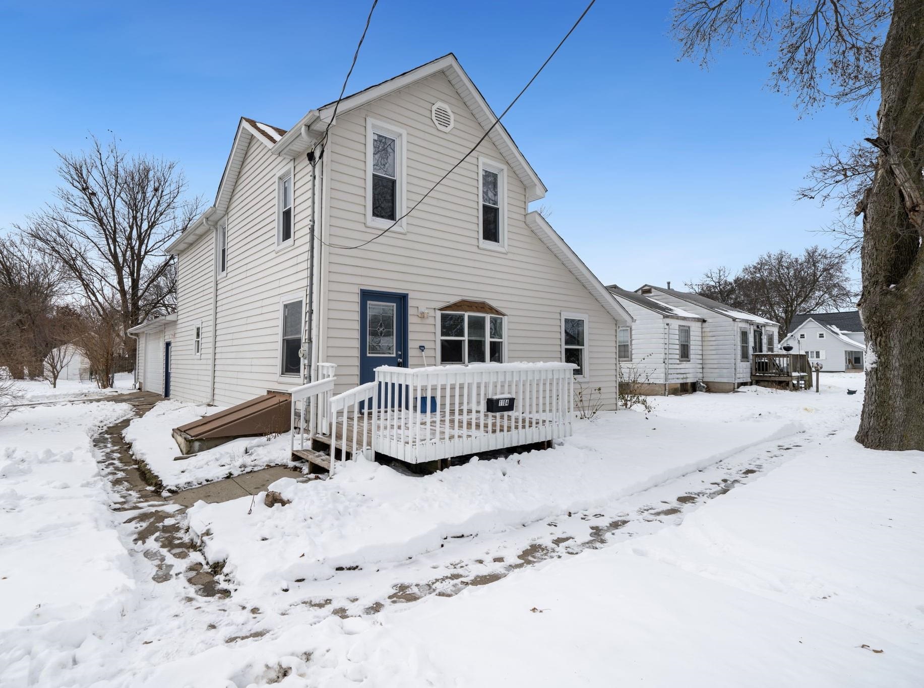 a front view of a house with a yard covered in snow