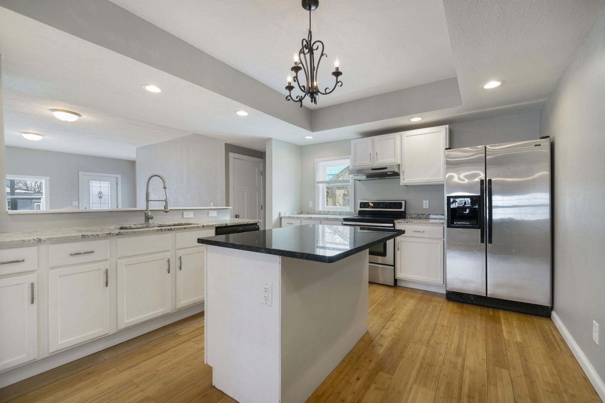 1104 South 4th Street Oregon, IL 61061 - Photo 14 of 36 a kitchen with stainless steel appliances granite countertop a sink a stove a refrigerator cabinets and a dining table with wooden floor